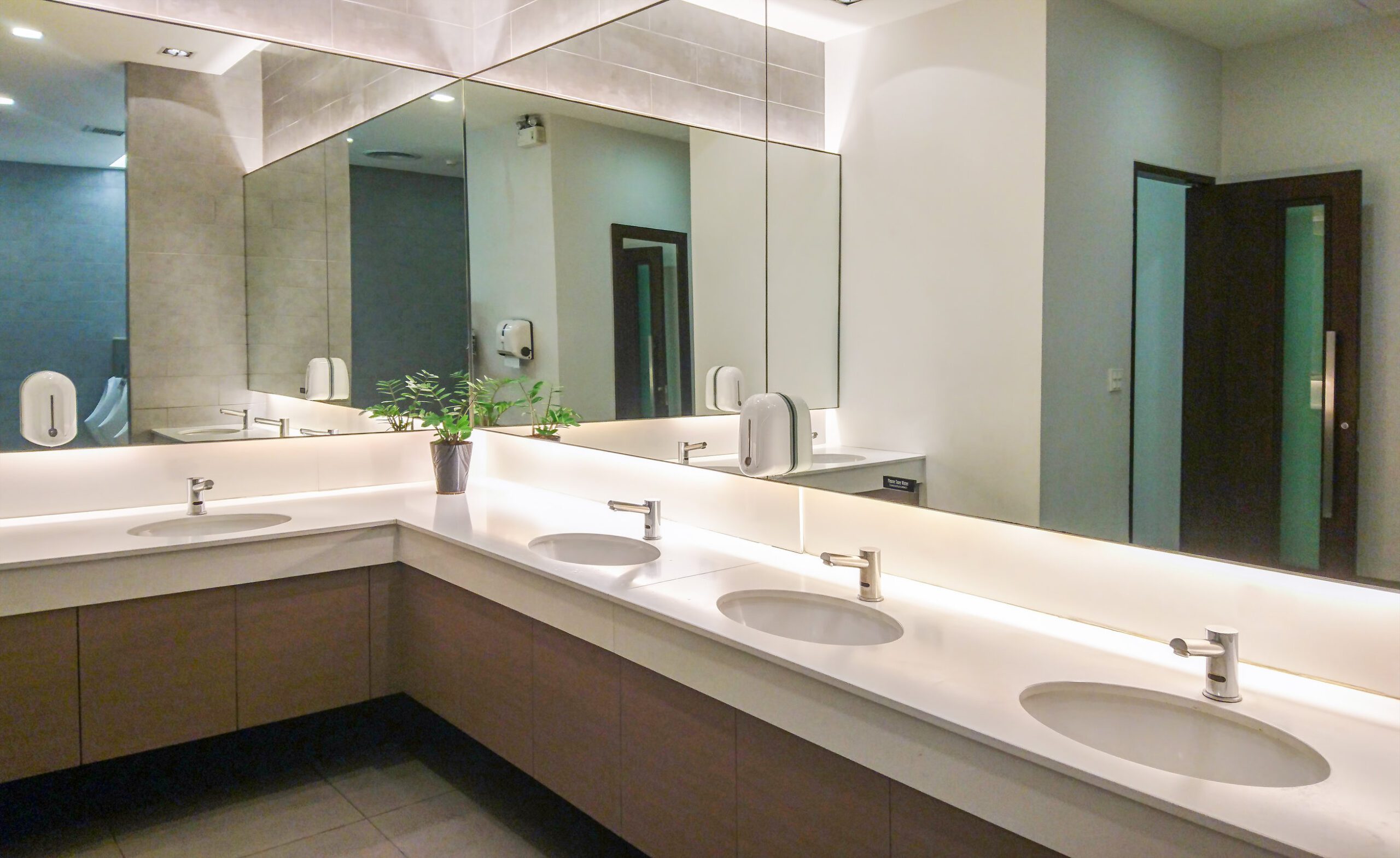Faucets with washbasin and big mirror Faucets with washbasin and big mirror in public restroom